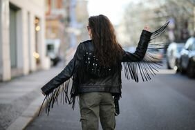 Frankie Miles wears a fringe leather jacket, a rock concert outfit idea for 2023.