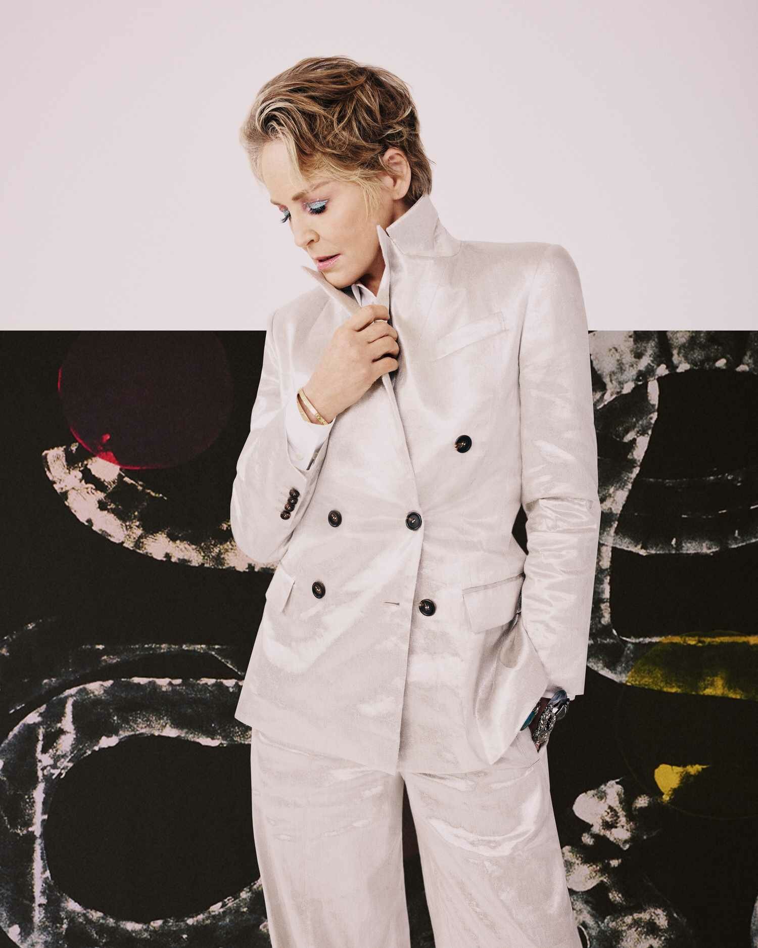 Sharon Stone Brunello Silver Suit in front of black painting
