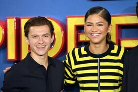 Tom Holland in a black polo with Zendaya in a black and yellow striped top