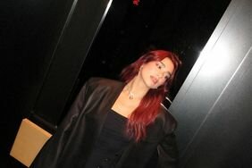Dua Lipa Red Hair Posing in Black Dress With Snaps and High Slit Black Trench Coat