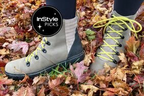 A person wearing the Bogs Women's Holly Lace Leather Boots in wet leaves