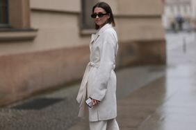 A woman wears a white trench coat