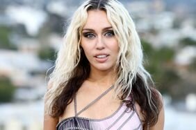 Miley Cyrus Half Smile Blonde Hair Brunette Undertones Pink and Black Dress Versace Fall/Winter 2023 Show