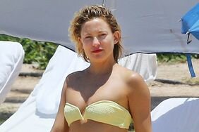 Kate Hudson shows off her bikini bod in a tiny yellow bikini while on vacation with her mom Goldie Hawn. The pair seem to be having fun themselves as they enjoy the sand and surf of Hawaii.