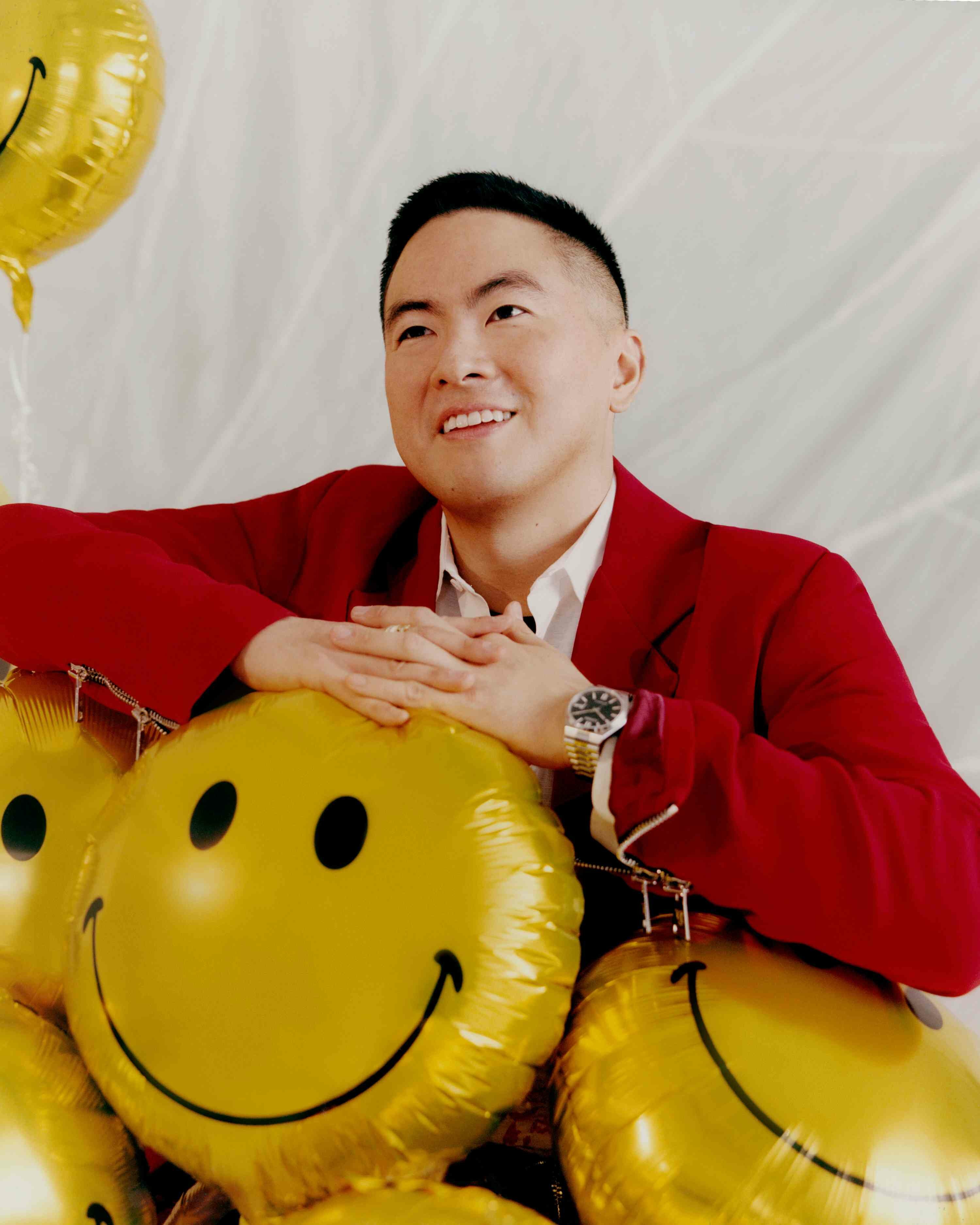 This Guy: Bowen Yang red suit smiley face balloons