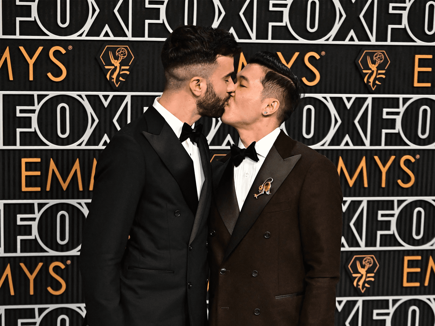 Joel Kim Booster and John-Michael Sudsina kissing on the Emmys red carpet