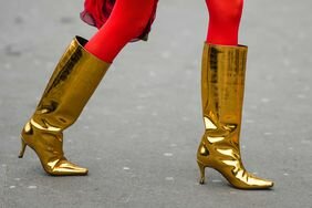 A woman wears one of fall's most wearable NYFW shoe trends for fall: gold boots.