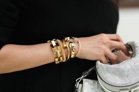 A woman wears gold designer bracelets from Cartier.