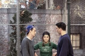 Chandler, Rachel, and Ross from Friends outside in sweats with autumn leaves strewn on the ground