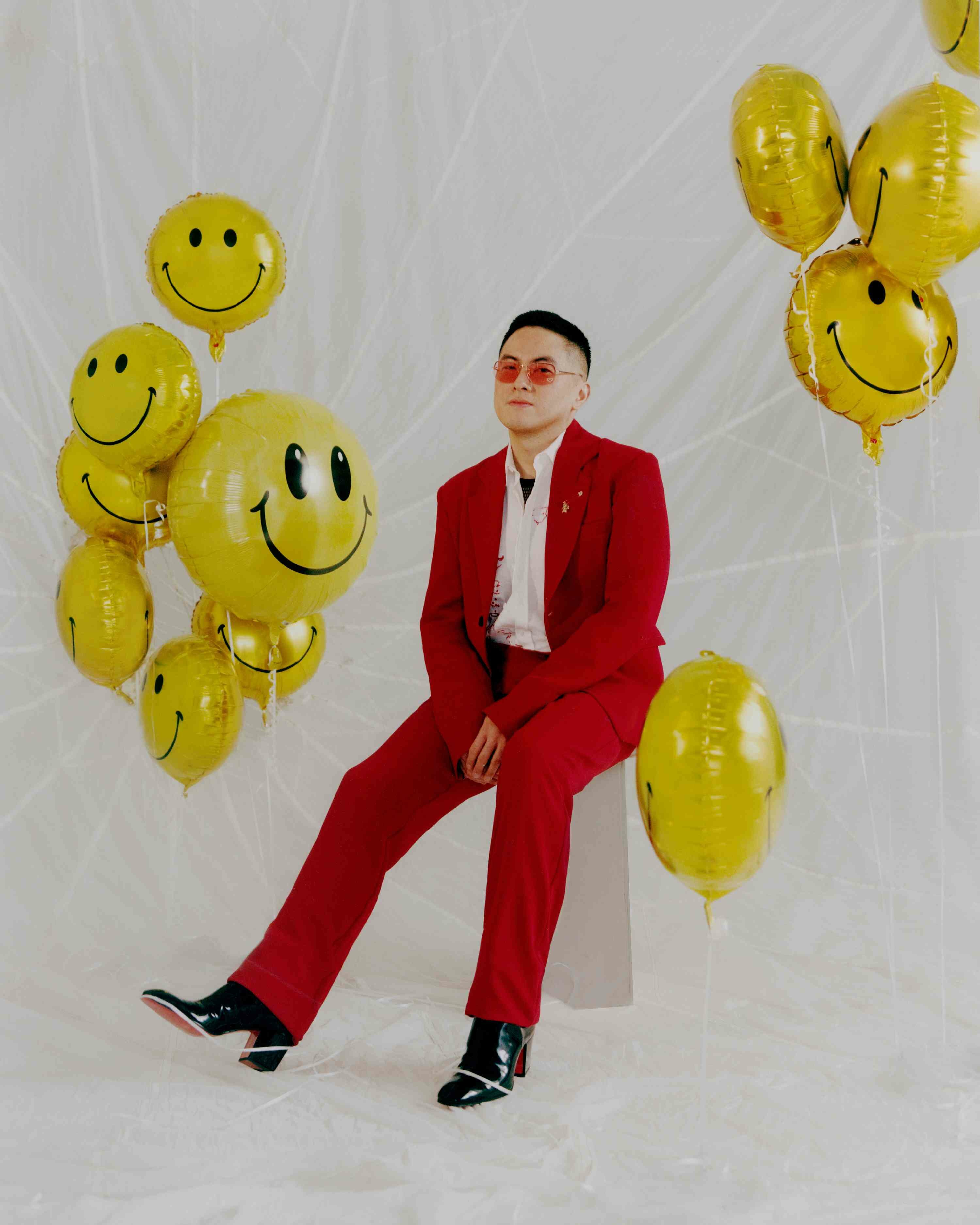 This Guy: Bowen Yang red suit smiley face balloons