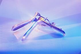 Dilation and curettage clamp on a blue background.