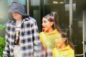 Pete Davidson and Ariana Grande walking together while sucking on lollipops