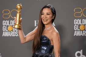 Michelle Yeoh holding her golden globe