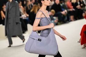 A models holds an oversized bag, one of the best 2023 fall bag trends on the Ferragamo runway.