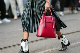 Jacqueline Barth shows how to style cowboy boots by wearing black and white and snakeskin cowboy boots with a pleated skirt and red bag.