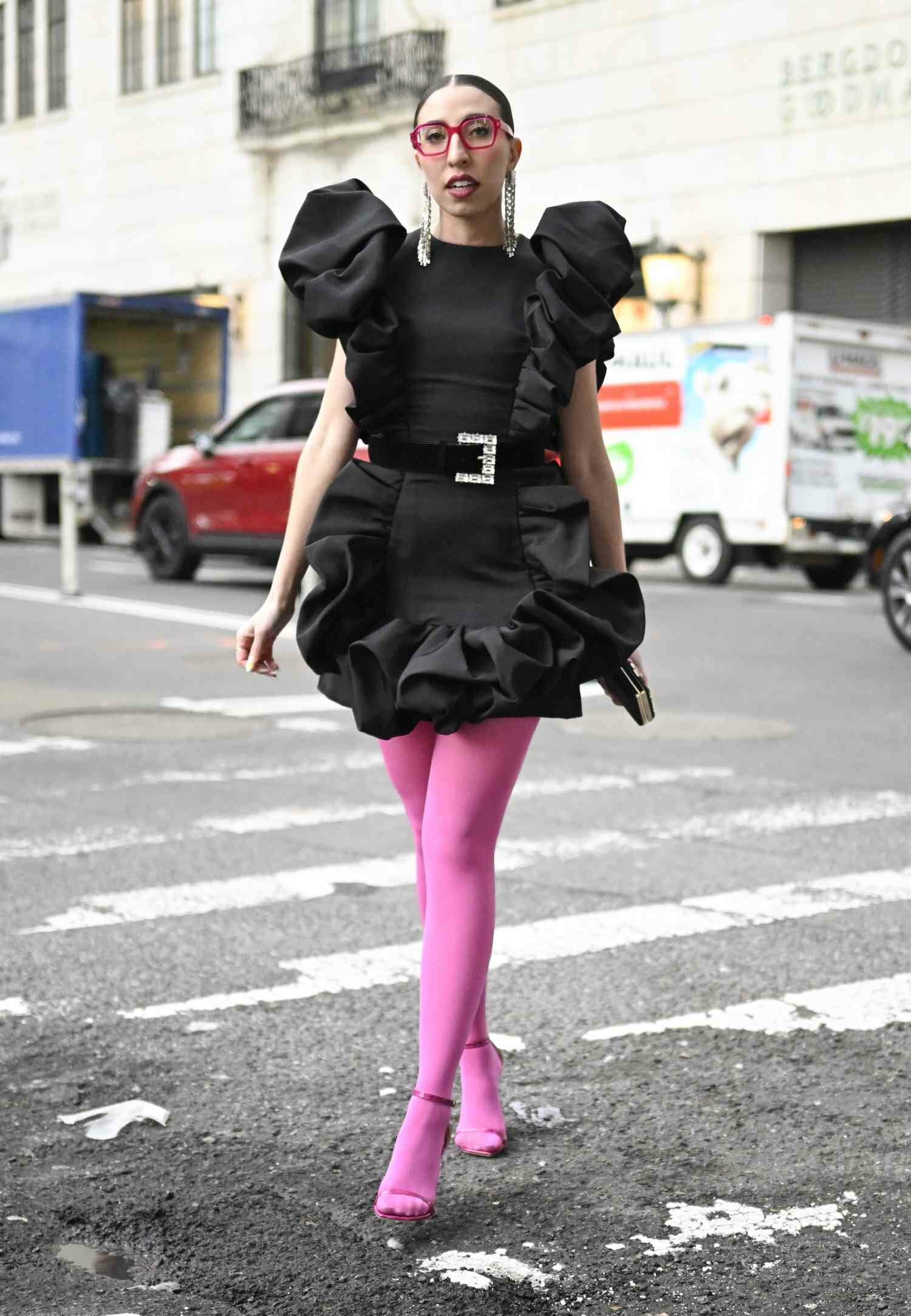Caroline Vazzana wears pink tights and a black dress, one of the best NYFW street style looks of 2024.